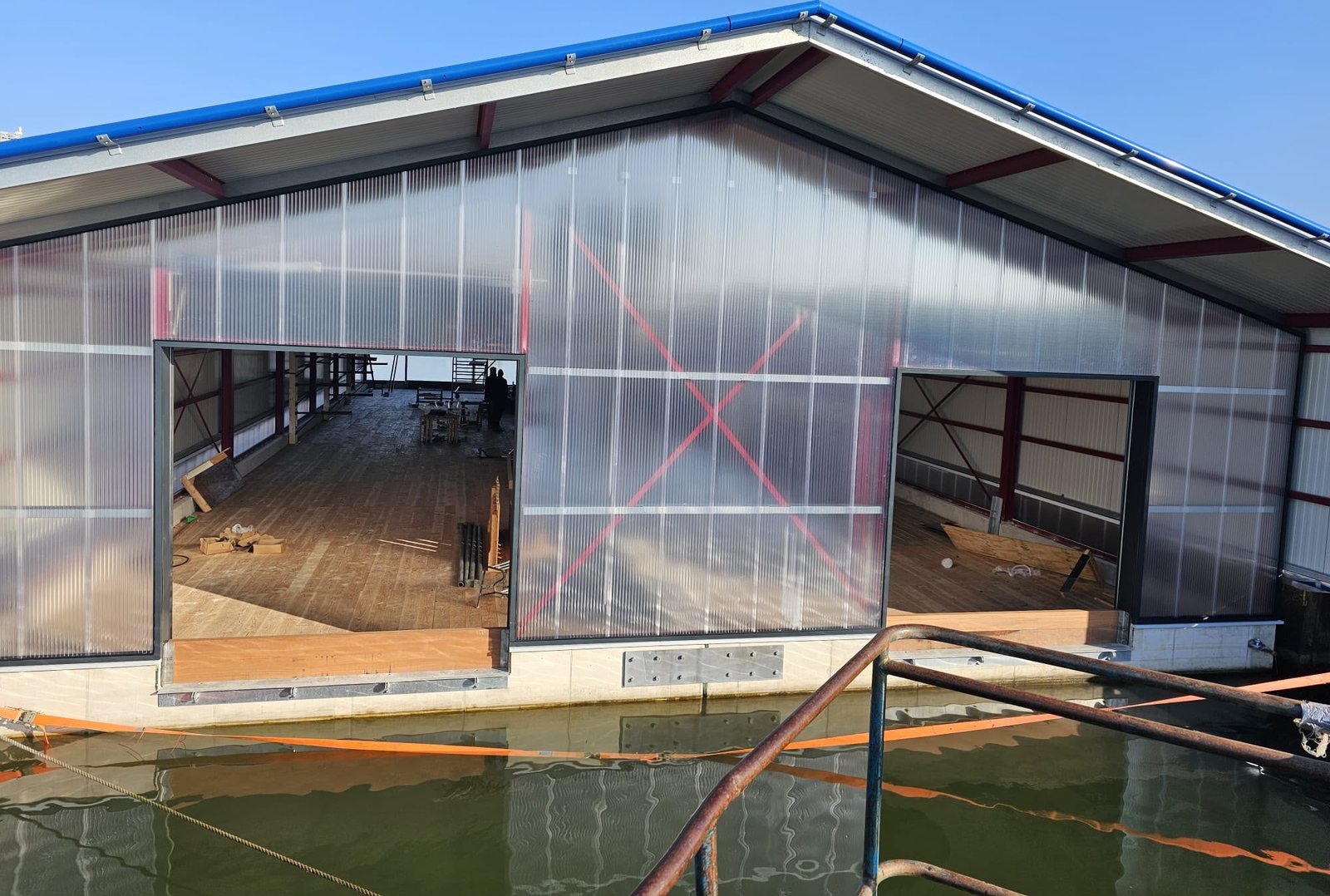 Bedrijfshal in aanbouw met stalen spanten en gevelbeplating