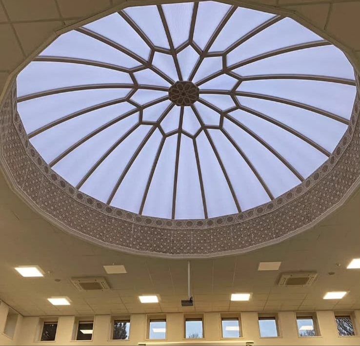 Grote ronde lichtkoepel met fijnmazige roedeverdeling in het plafond van een moskee