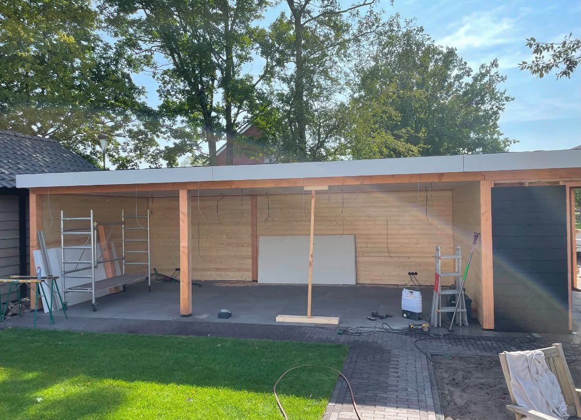 Afgewerkte houten veranda met overkapping en berging in de tuin