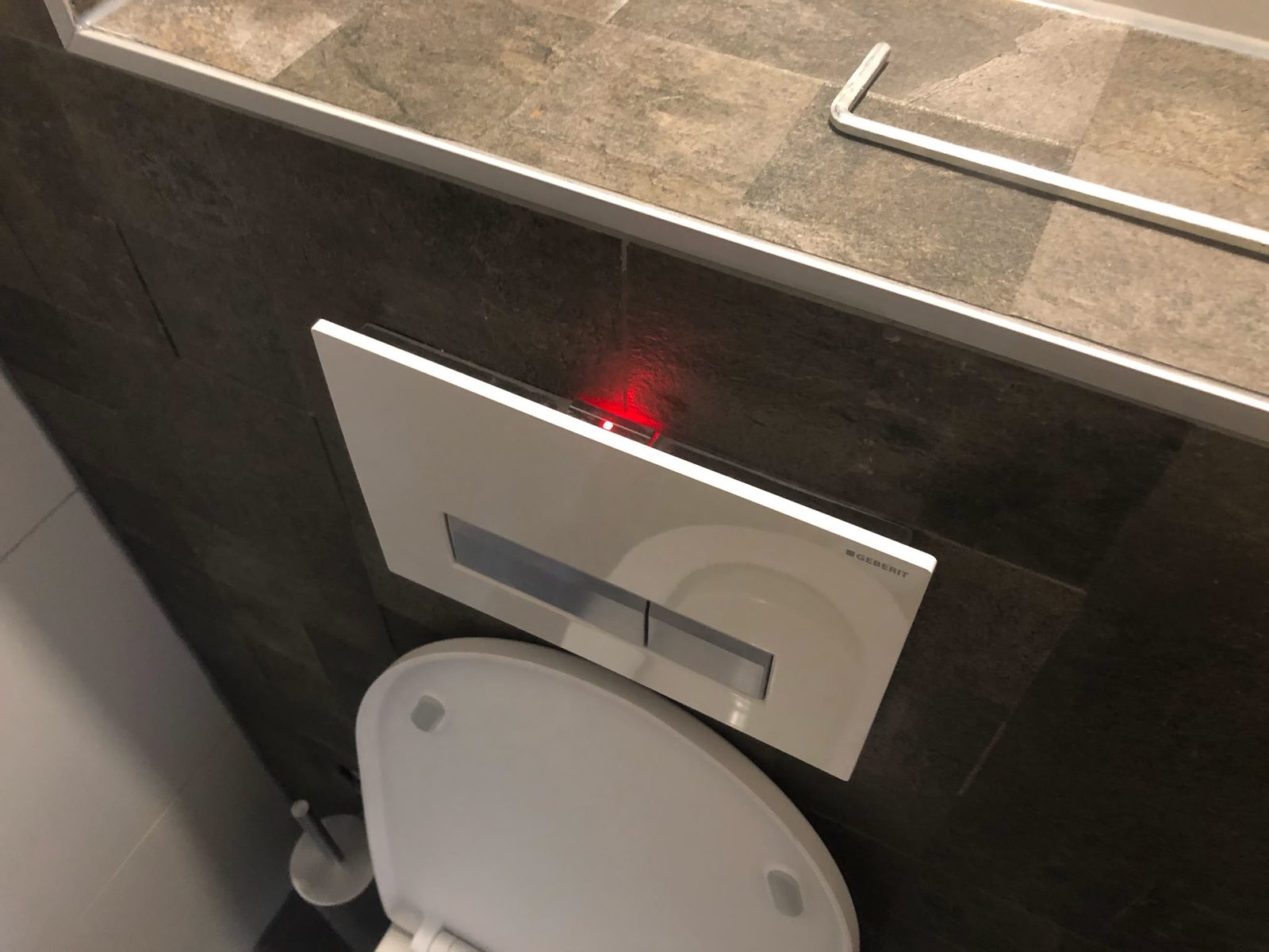 Klus in Tiel: hangtoilet met nieuw bedieningspaneel in een betegelde voorzetwand
